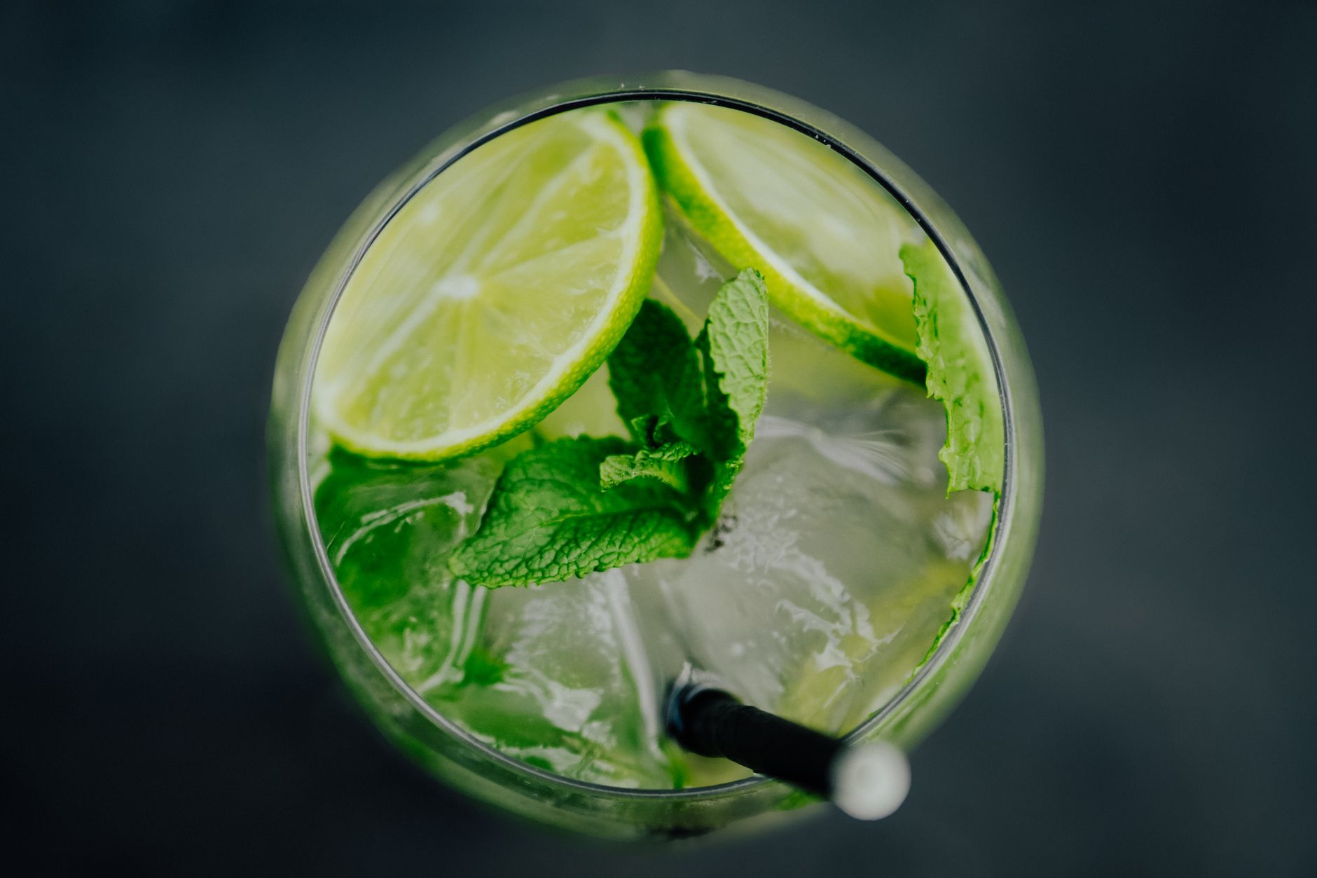 Alcoholvrije Nojito met verse munt en limoen geserveerd in een longdrinkglas met rietje