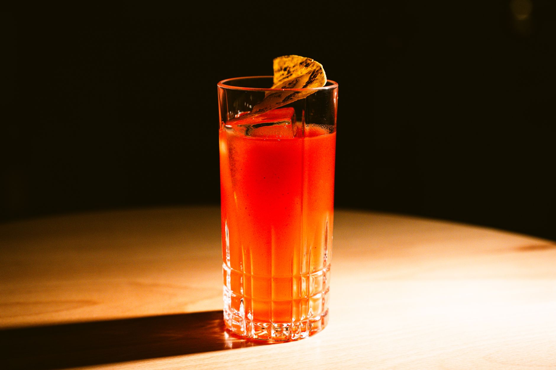 Sex on the Beach cocktail met kleurverloop in highballglas, gegarneerd met sinaasappel