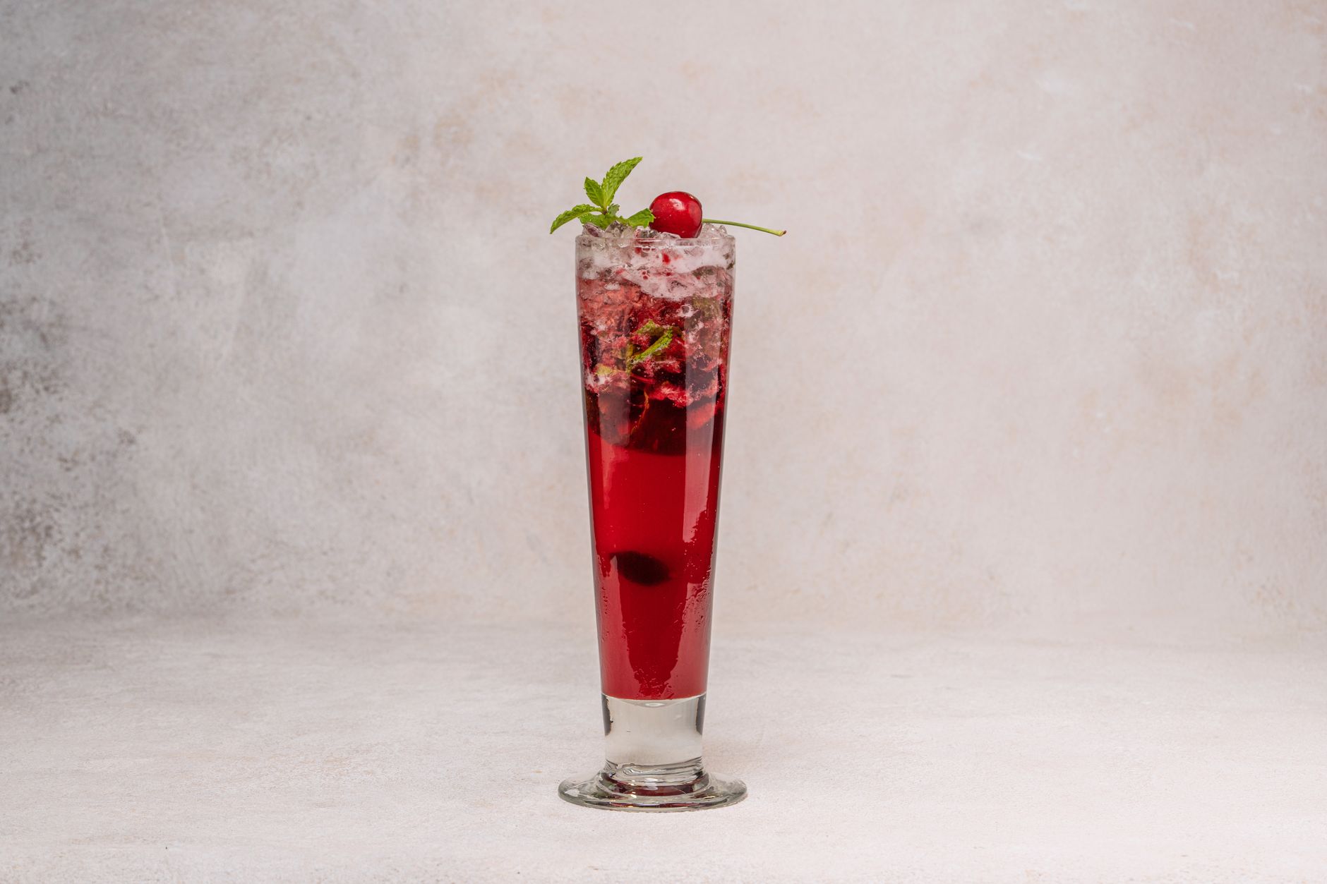 Glas Shirley Temple met gemberbier, grenadine en een cocktailkers als garnering