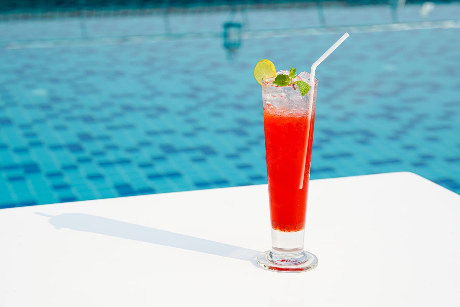 Watermeloen Cooler cocktail in highballglas met munt en schijfje watermeloen op zomers terras