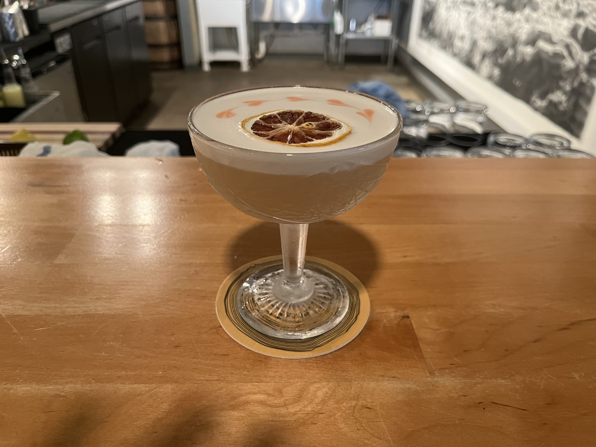 Whiskey Sour in een rocksglas met schuimkraag en citroengarnering op een bar