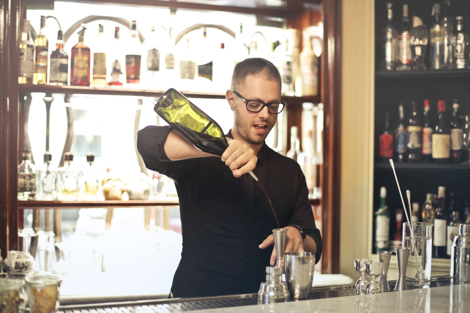 Fles gele Chartreuse tussen sterkedrank op een bartoog, gebruikt voor Martini-varianten