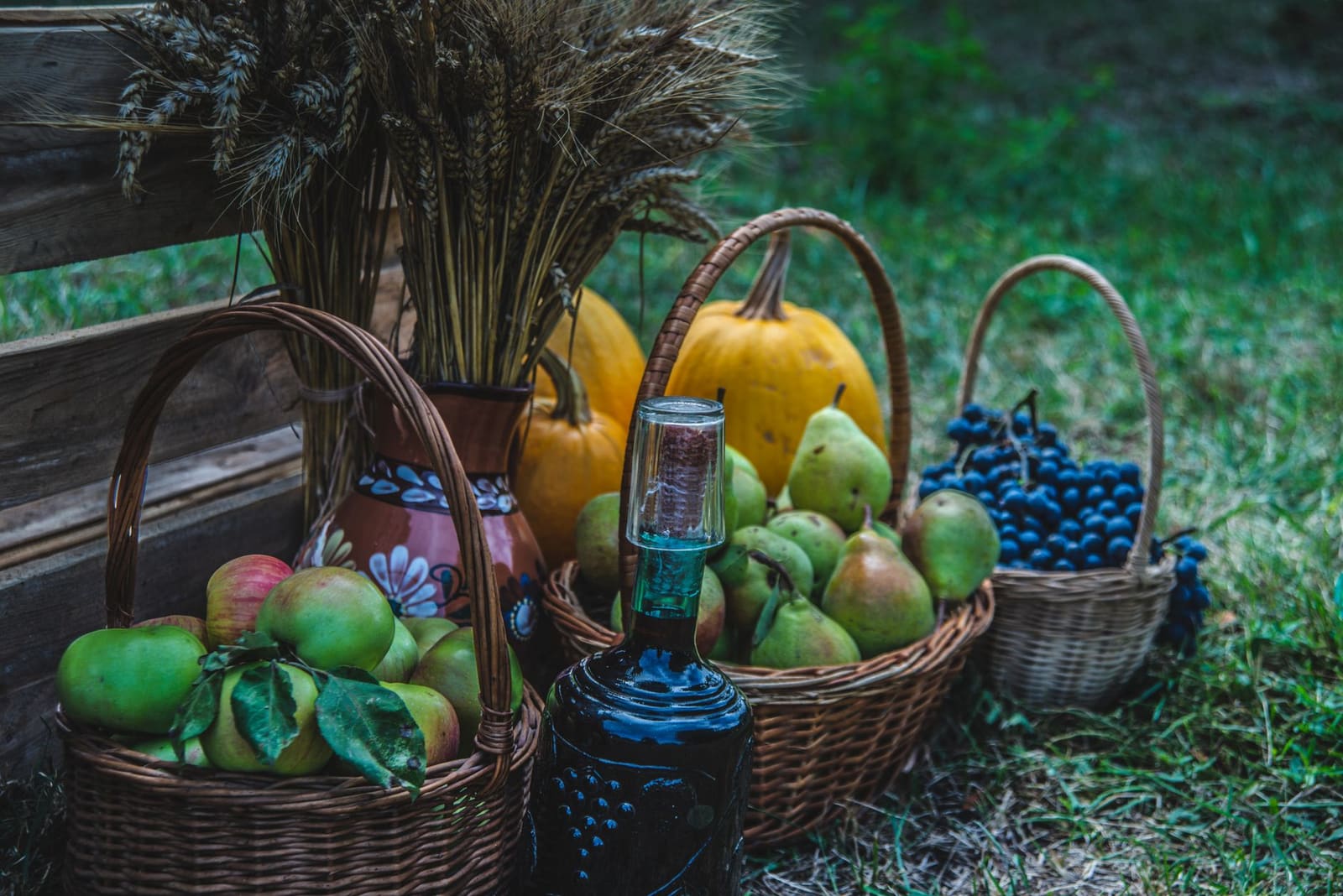 Fles cider naast verse appels op een houten tafel in natuurlijk licht