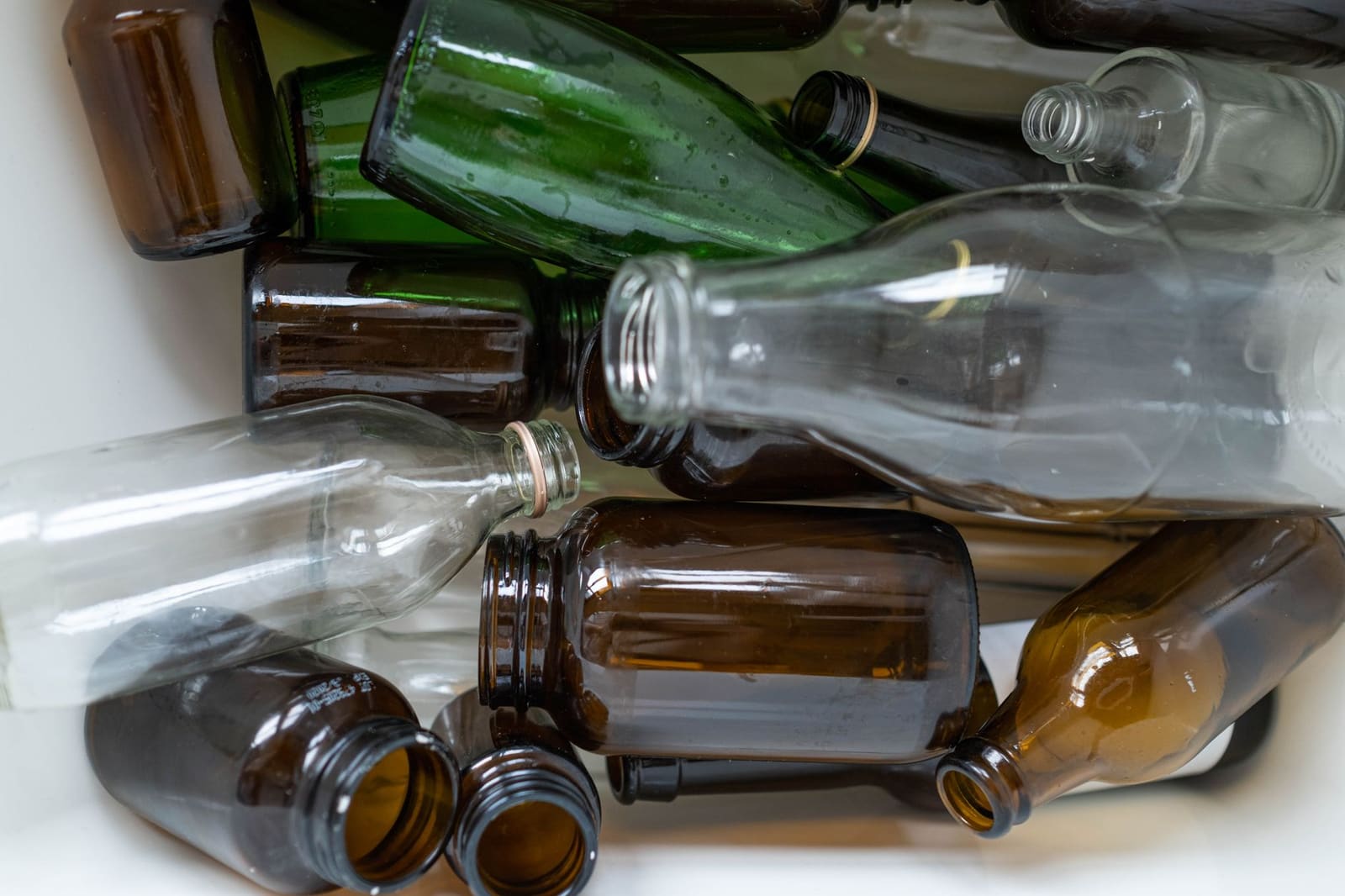 Stapel gerecyclede glazen flessen klaar voor hergebruik in de drankenindustrie
