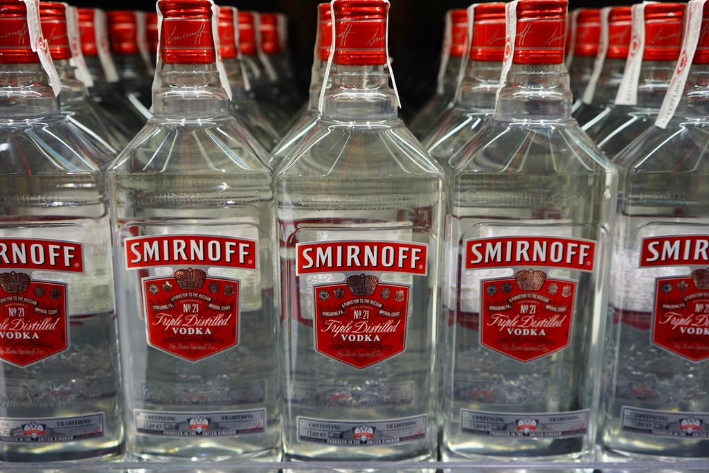 Rij wodkaflessen op een verlichte barplank, symbool voor de stabiele positie van wodka in de sterkedrankmarkt