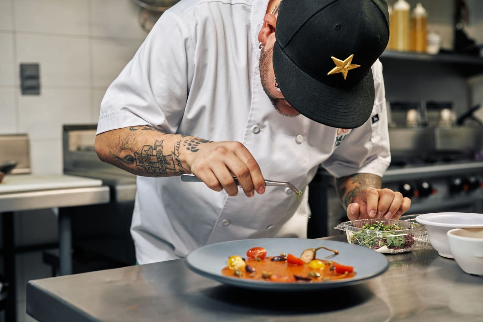 Chef-kok werkt geconcentreerd aan het opmaken van een bord