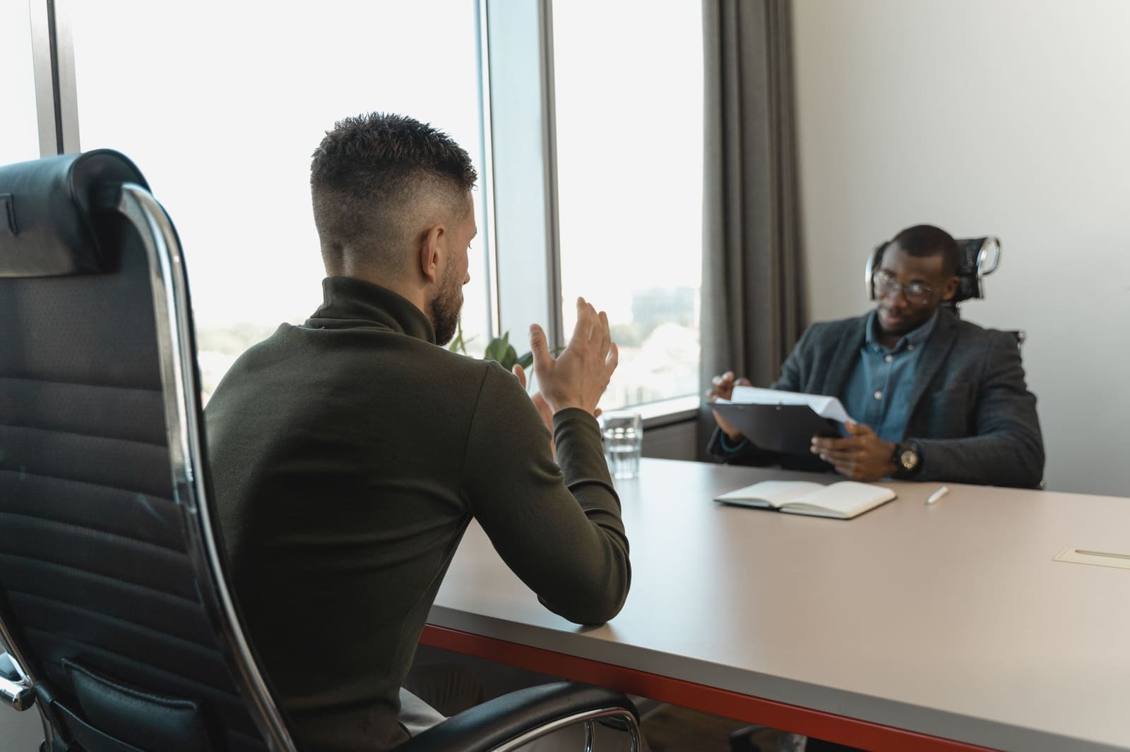 Sollicitatiegesprek aan een tafel, symbool voor het werven van nieuw horecapersoneel