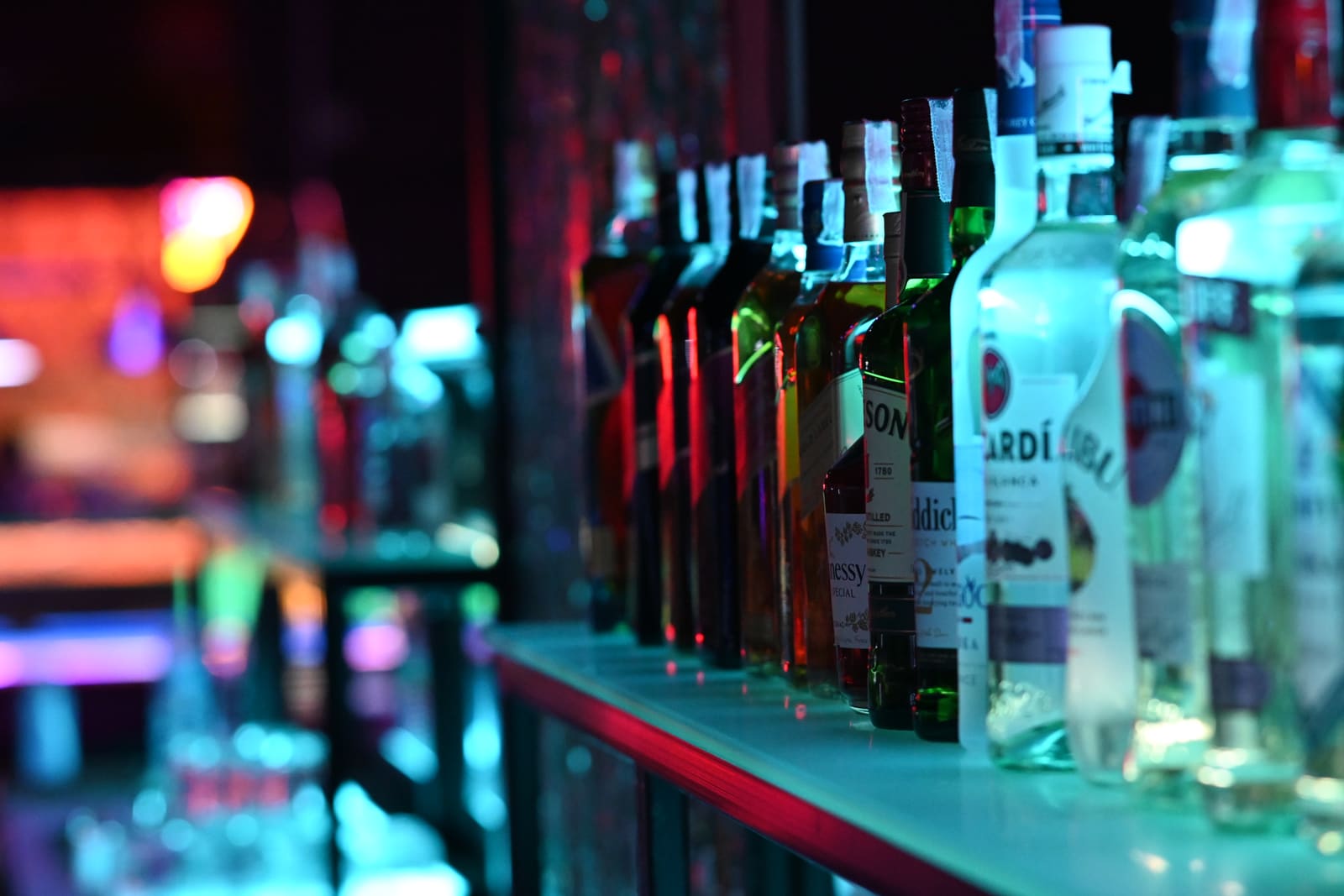 Rij drankflessen netjes uitgestald op een schap achter de bar