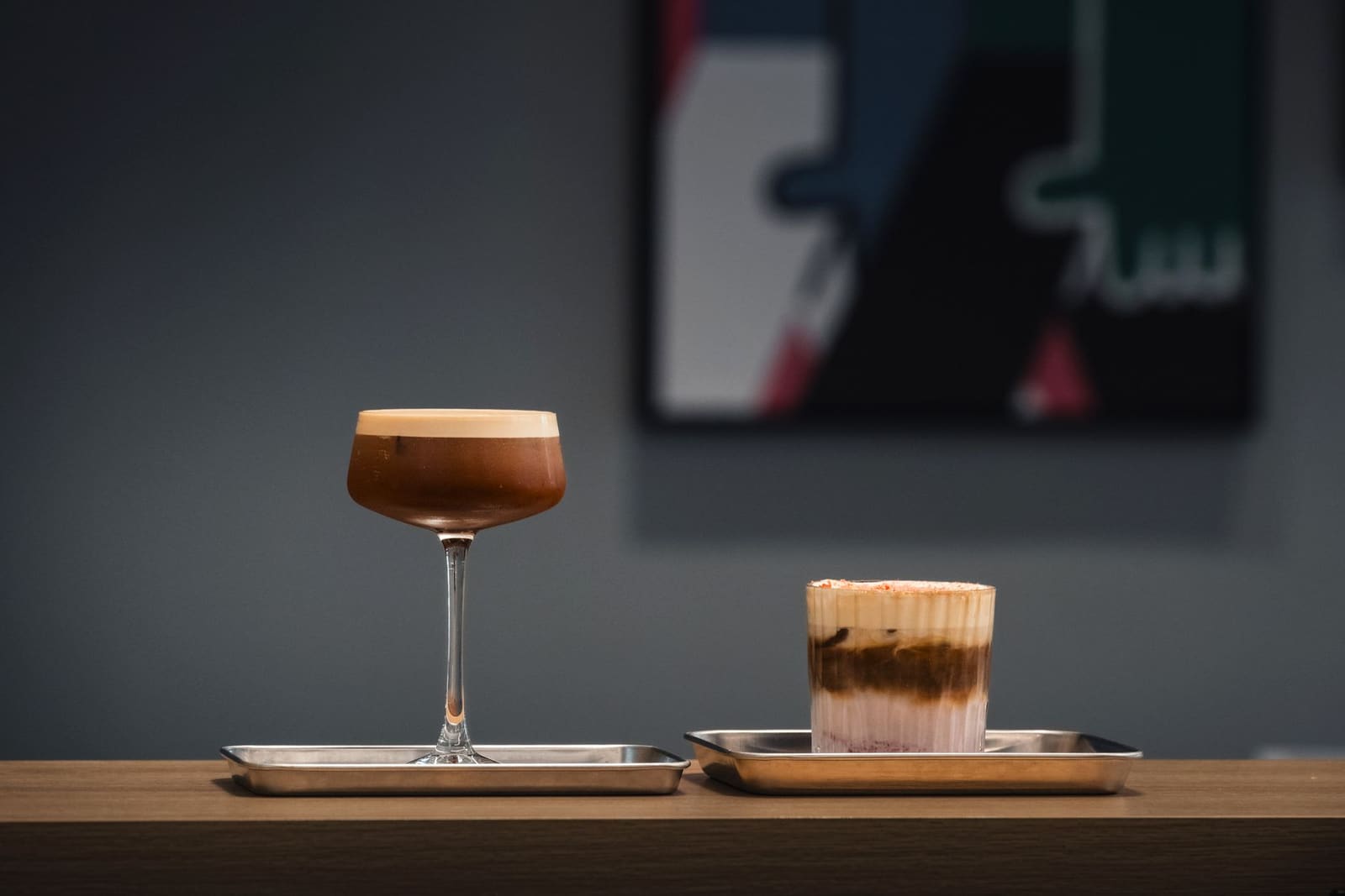 Cocktail geserveerd uit een glanzend metalen zakje op een bardienblad