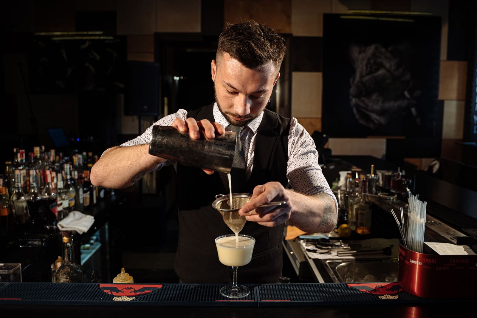 Bartender bereidt een cocktail tijdens een wedstrijdfinale op een verlicht podium