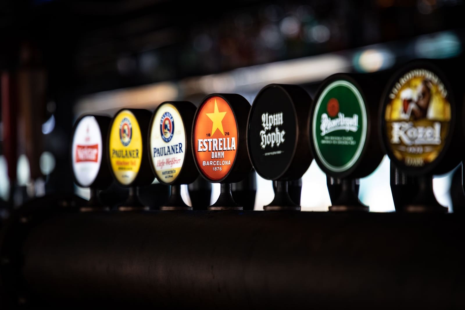 Rij bierkranen op de bar in een drukke pub
