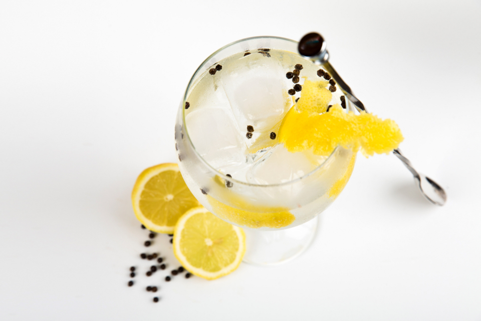 Een collins-cocktail in een hoog glas met ijs en citroen