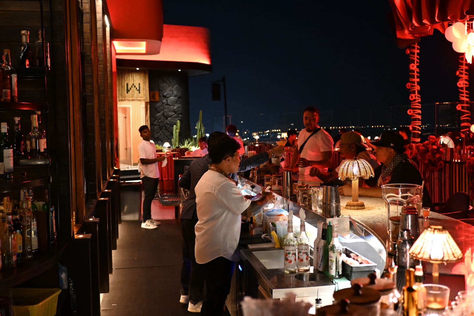 Barman achter de bar met glazen en flessen