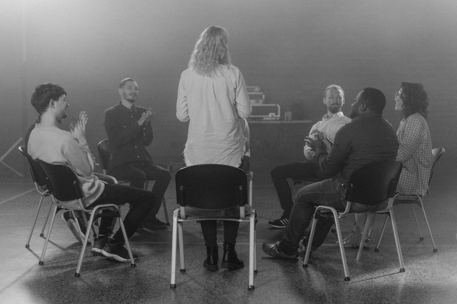 Mensen zitten in een kring op stoelen tijdens een steungroep