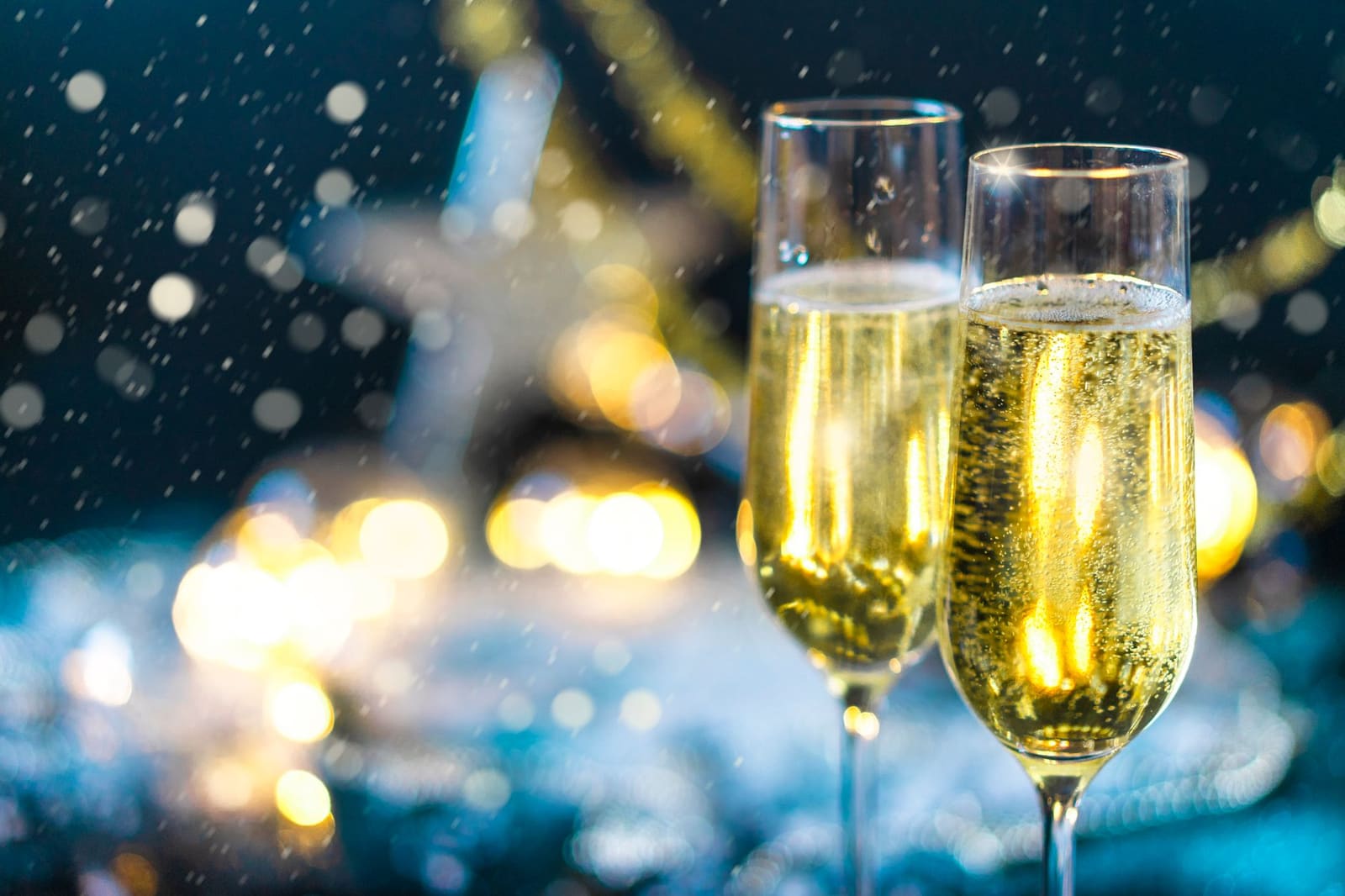 Close-up van opbruisende bubbels in een slanke champagneglas tegen een donkere achtergrond.