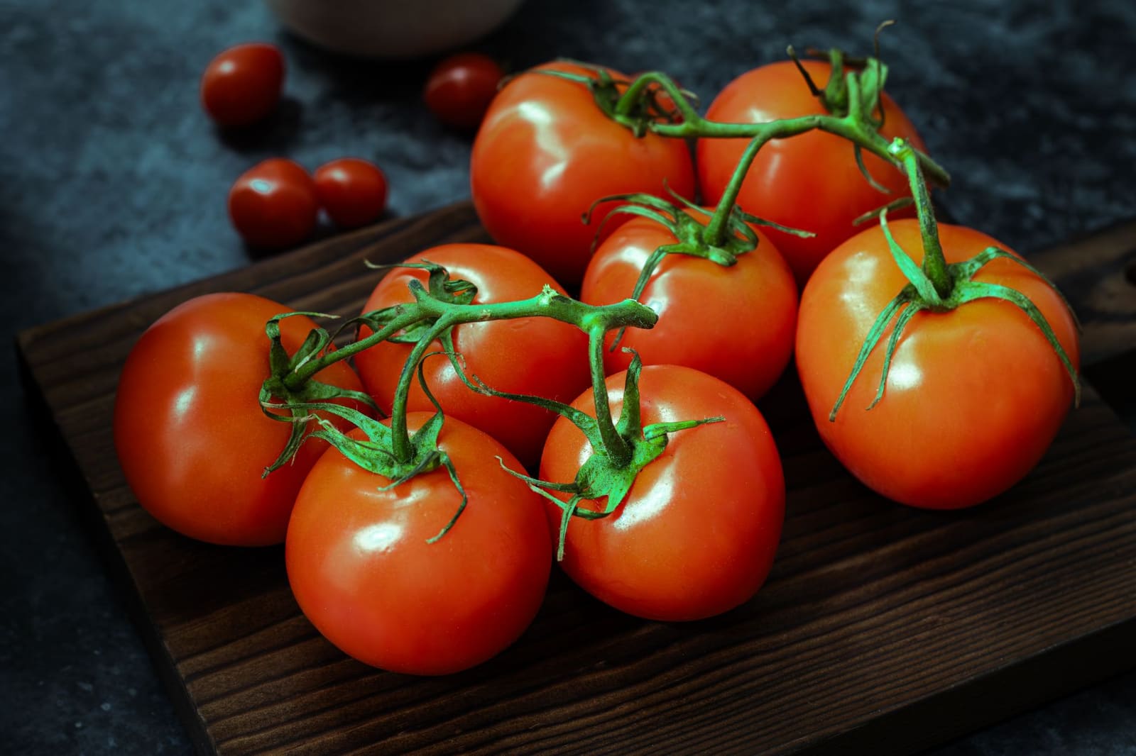 Verse rijpe tomaten uitgestald op een houten snijplank in daglicht