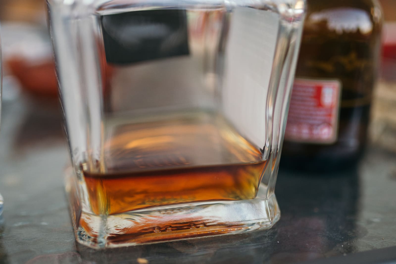 Glas amberkleurige whiskey op een donkere tafel