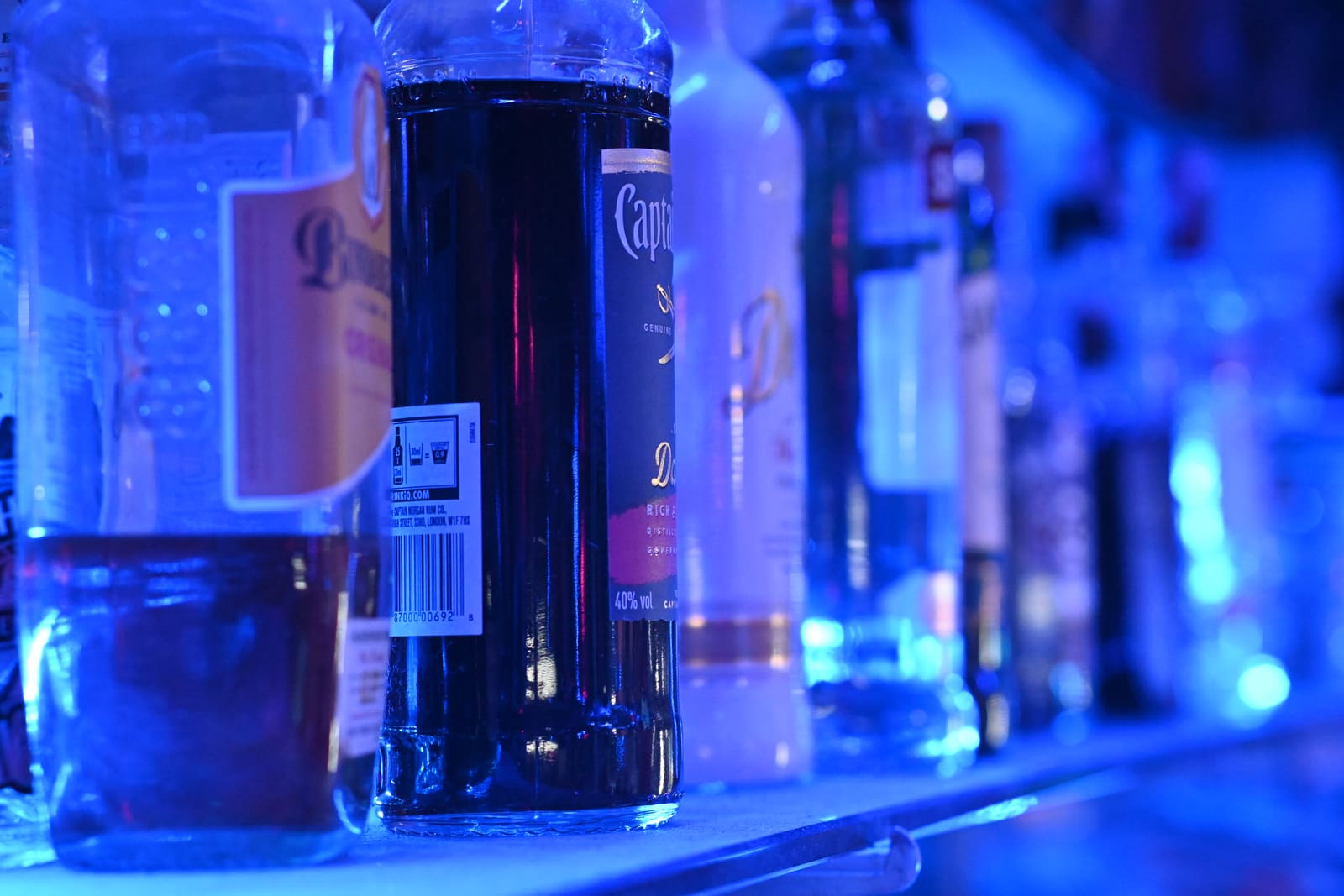 Rij nieuwe drankflessen op een schap in een bar, klaar voor gebruik