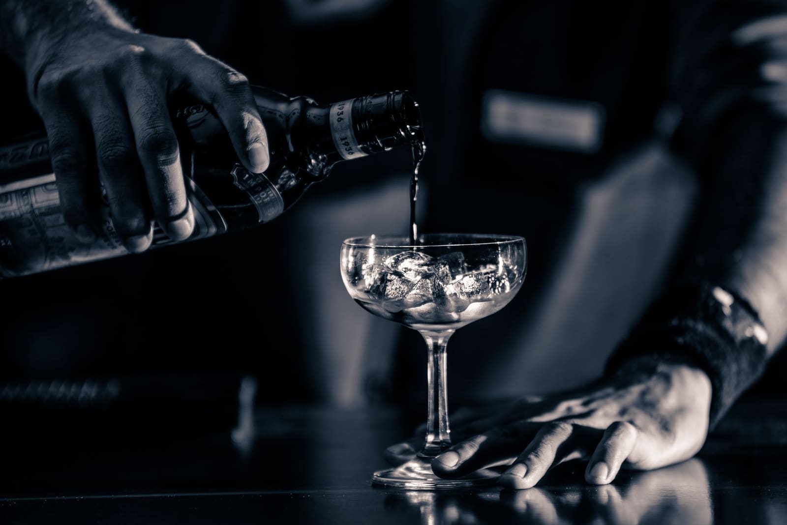 Bartender schenkt een verse cocktail in een glas achter de bar