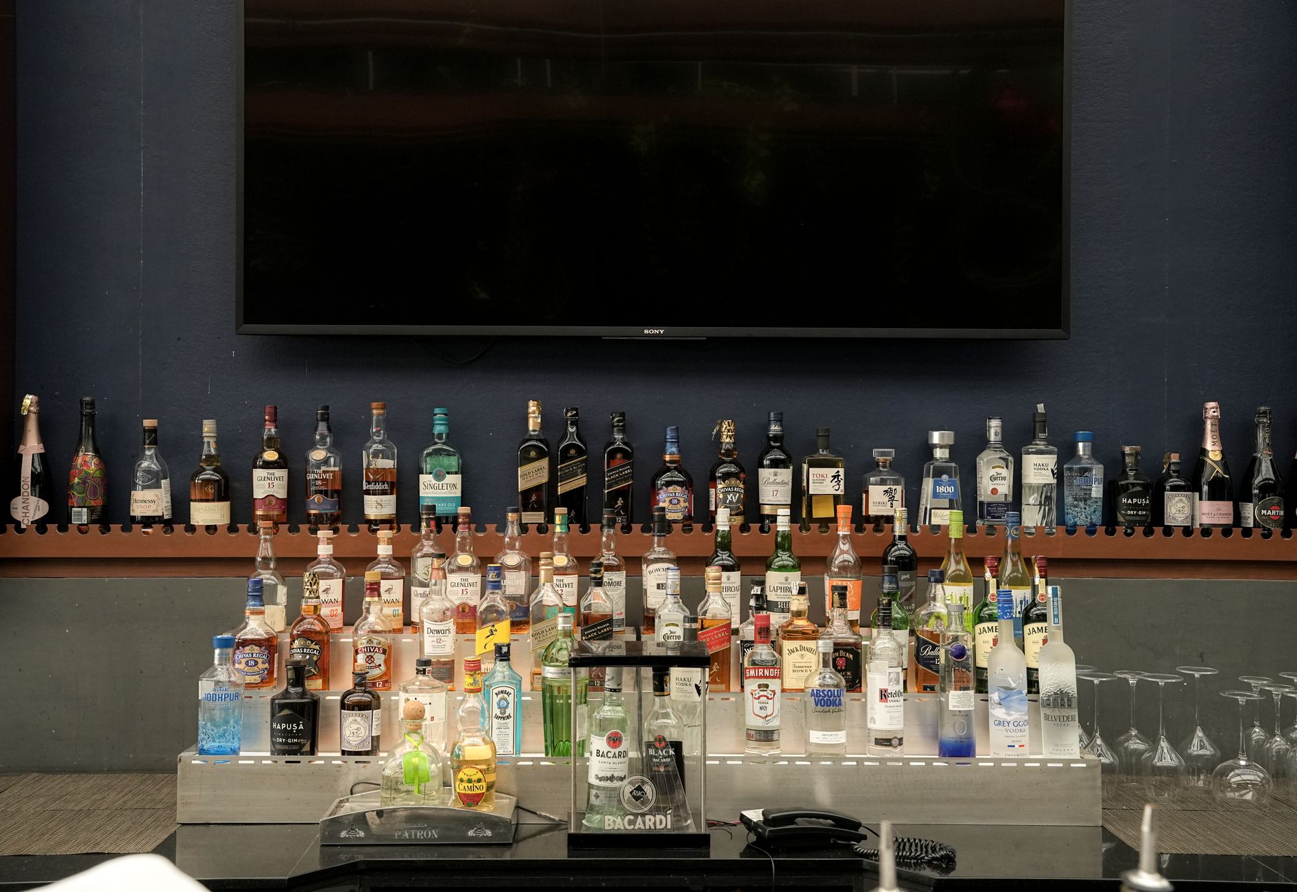 Rij nieuwe drankflessen op een bar, van tequila tot likeur, klaar voor de zomer van 2026