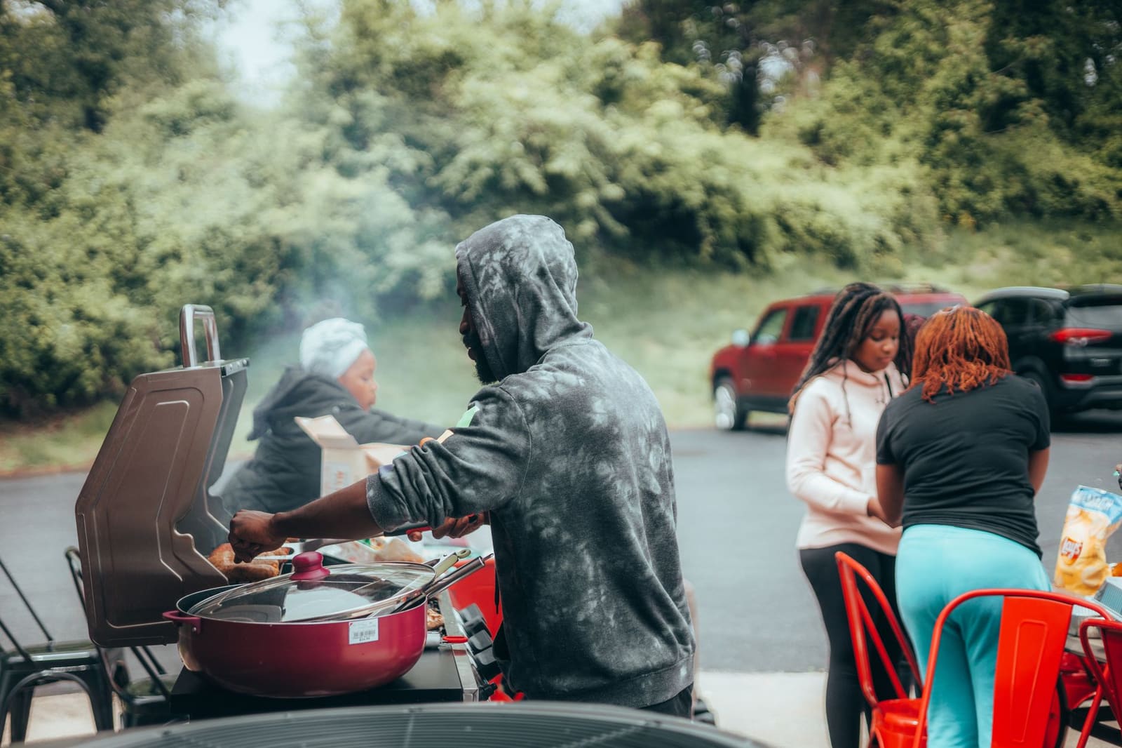 Mensen verzamelen bij auto's op een parkeerterrein voor een tailgate feest