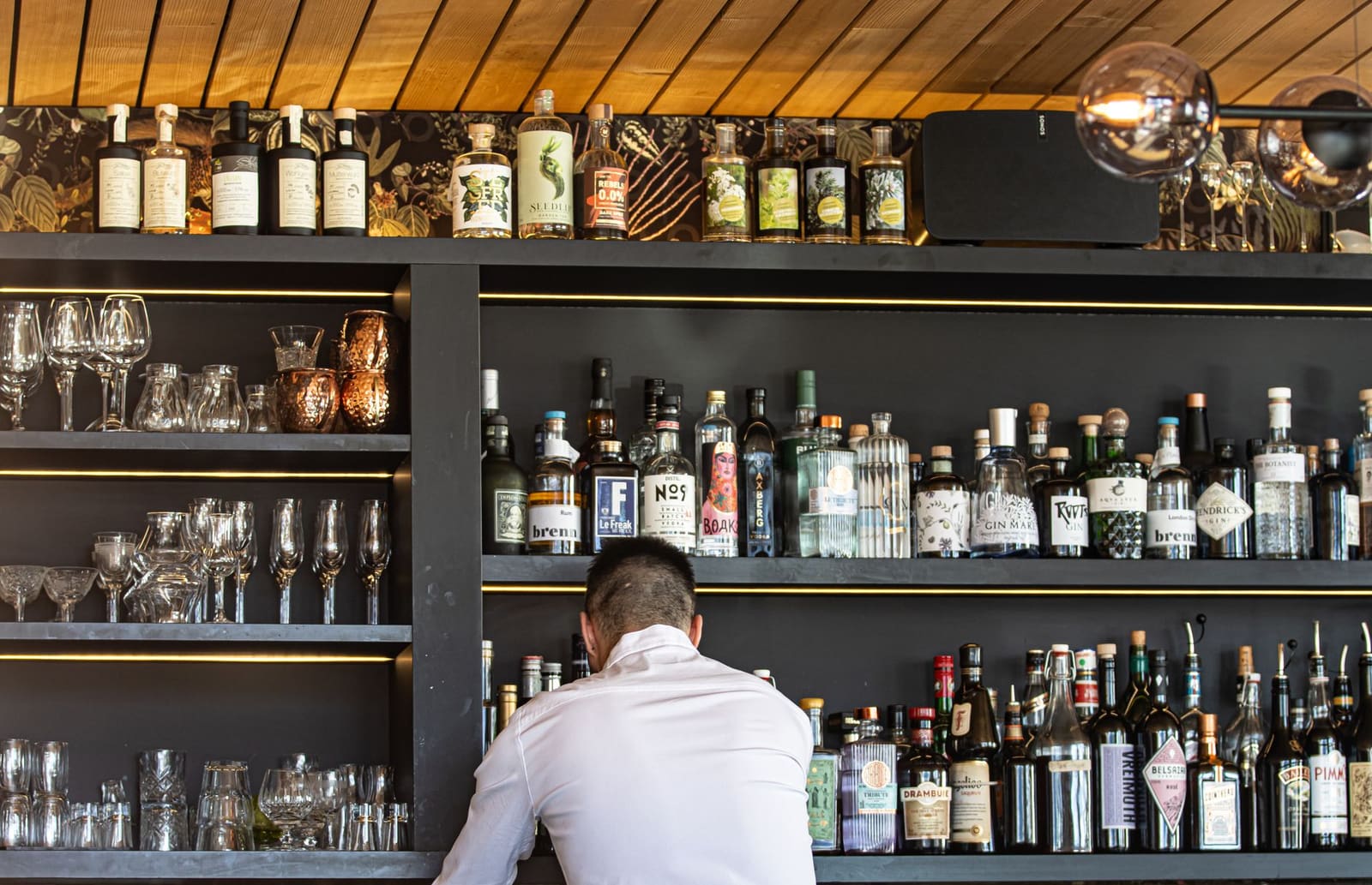 Diverse flessen rum naast elkaar op een houten schap