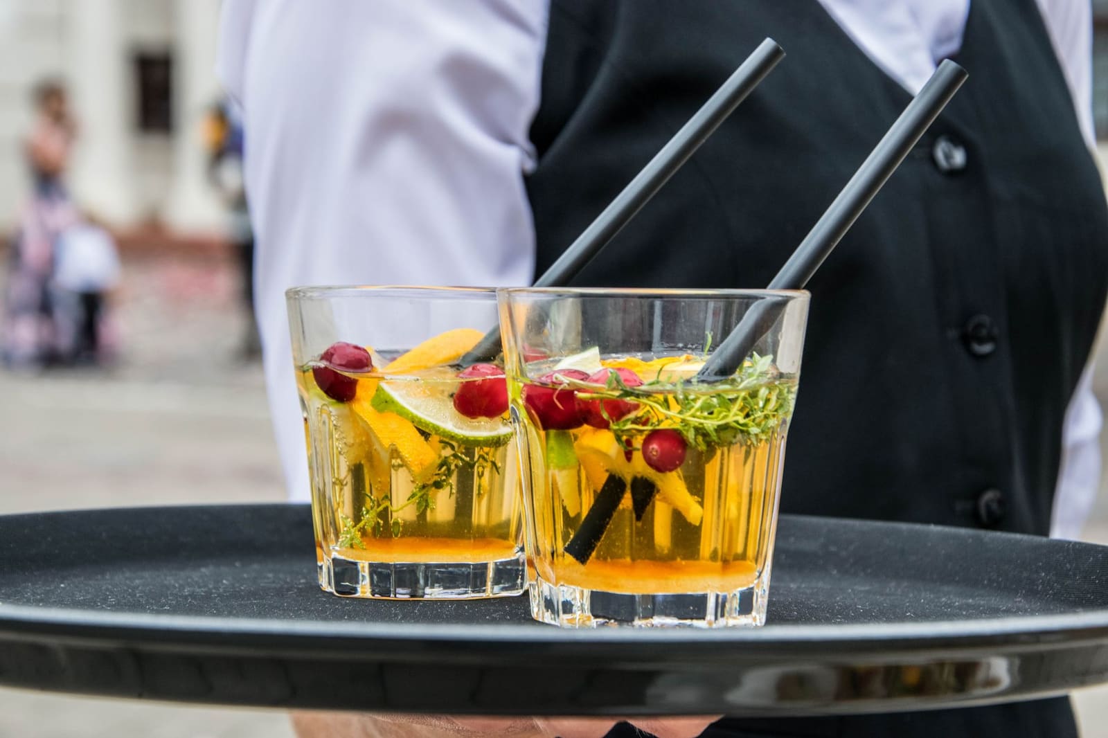 Vers gesneden citroen en kruiden als garnering naast een cocktail