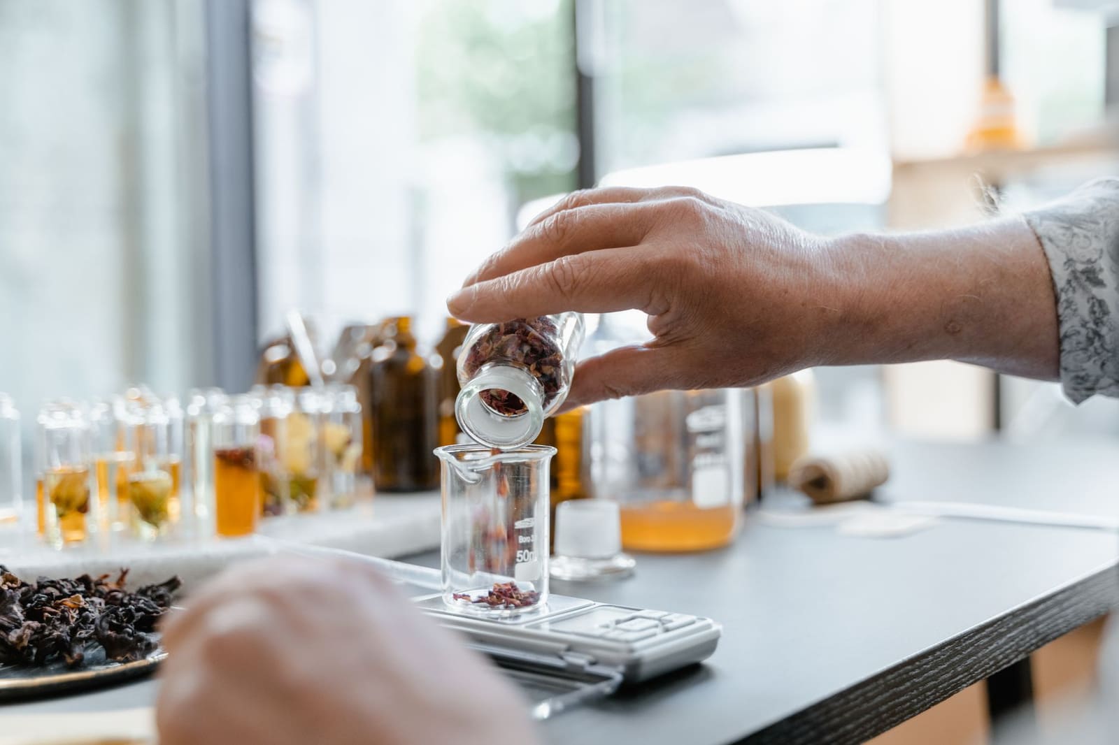 Glazen potten met infusies en kruiden op een werkblad