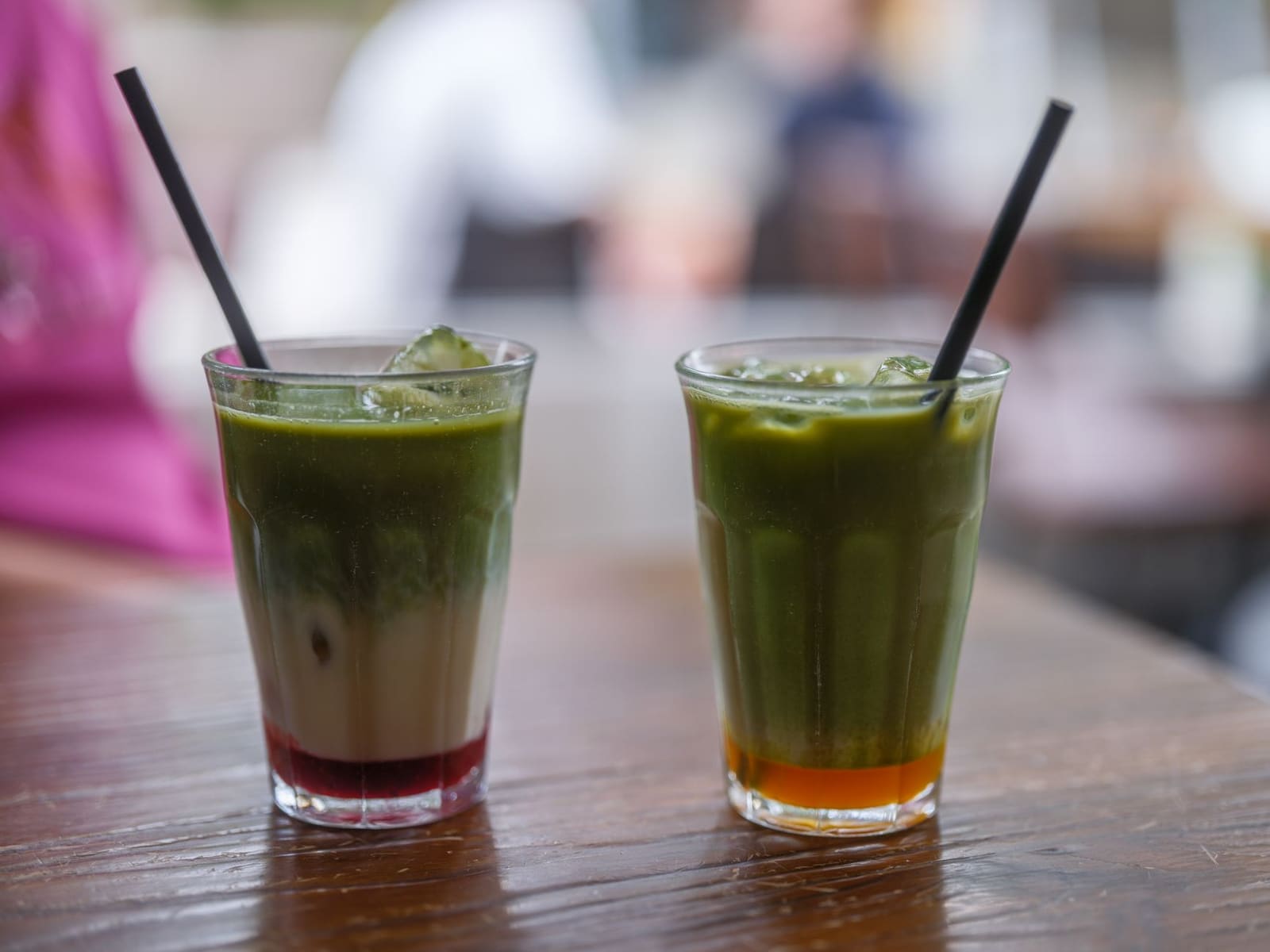 Een groene matcha-cocktail met ijs geserveerd in een hoog glas
