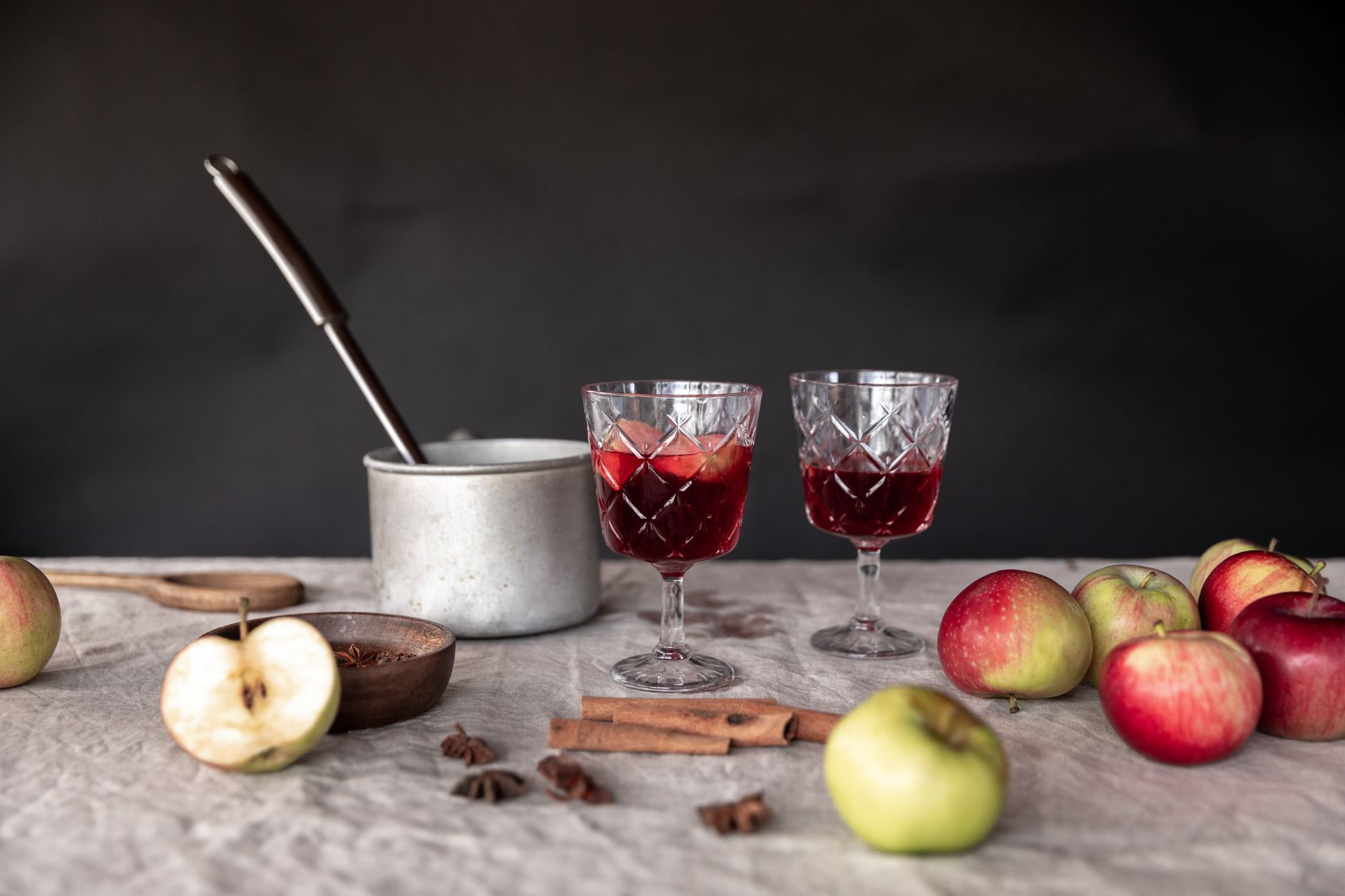 Een warme, gekruide mulled cider cocktail met citrusschijfjes in een glas op een herfstige bar