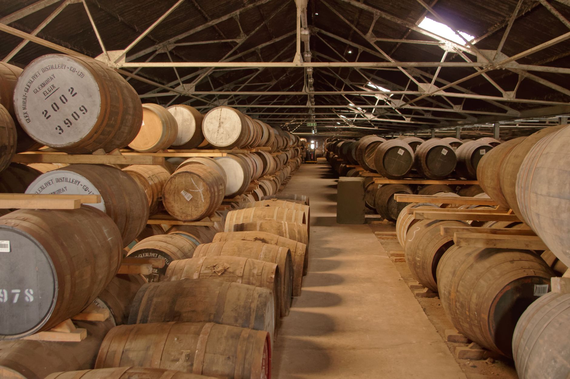 Rijen eikenhouten whiskyvaten in een niet-klimaatgecontroleerd pakhuis waar Virginia Distillery Co zijn whisky laat rijpen