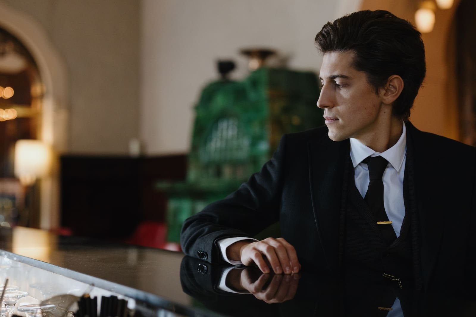 Bartender maakt een cocktail achter een elegante hotelbar met glimmende glazen op de toog