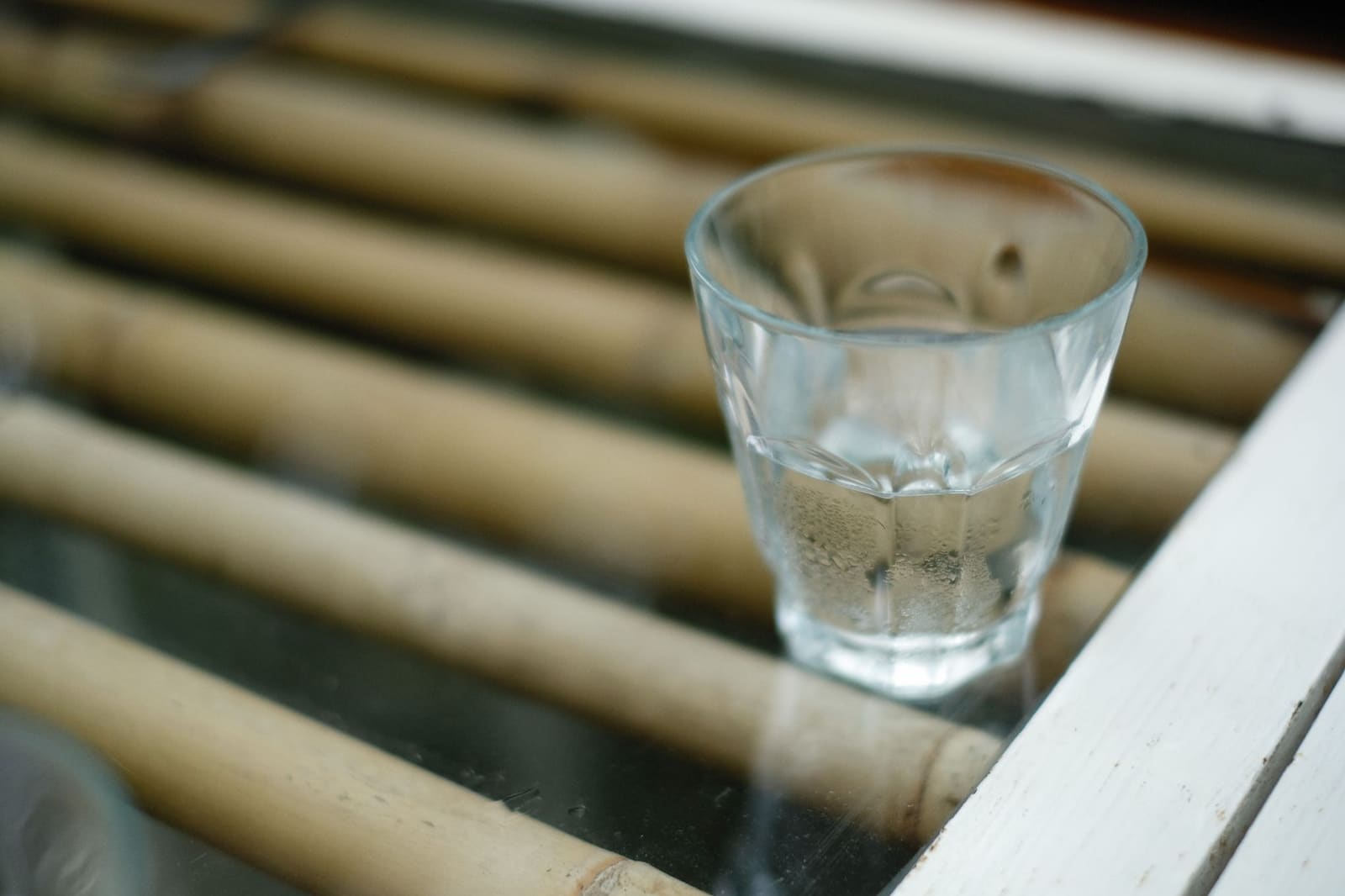 Glas water naast een keel en stembanden symboliserend stemverzorging