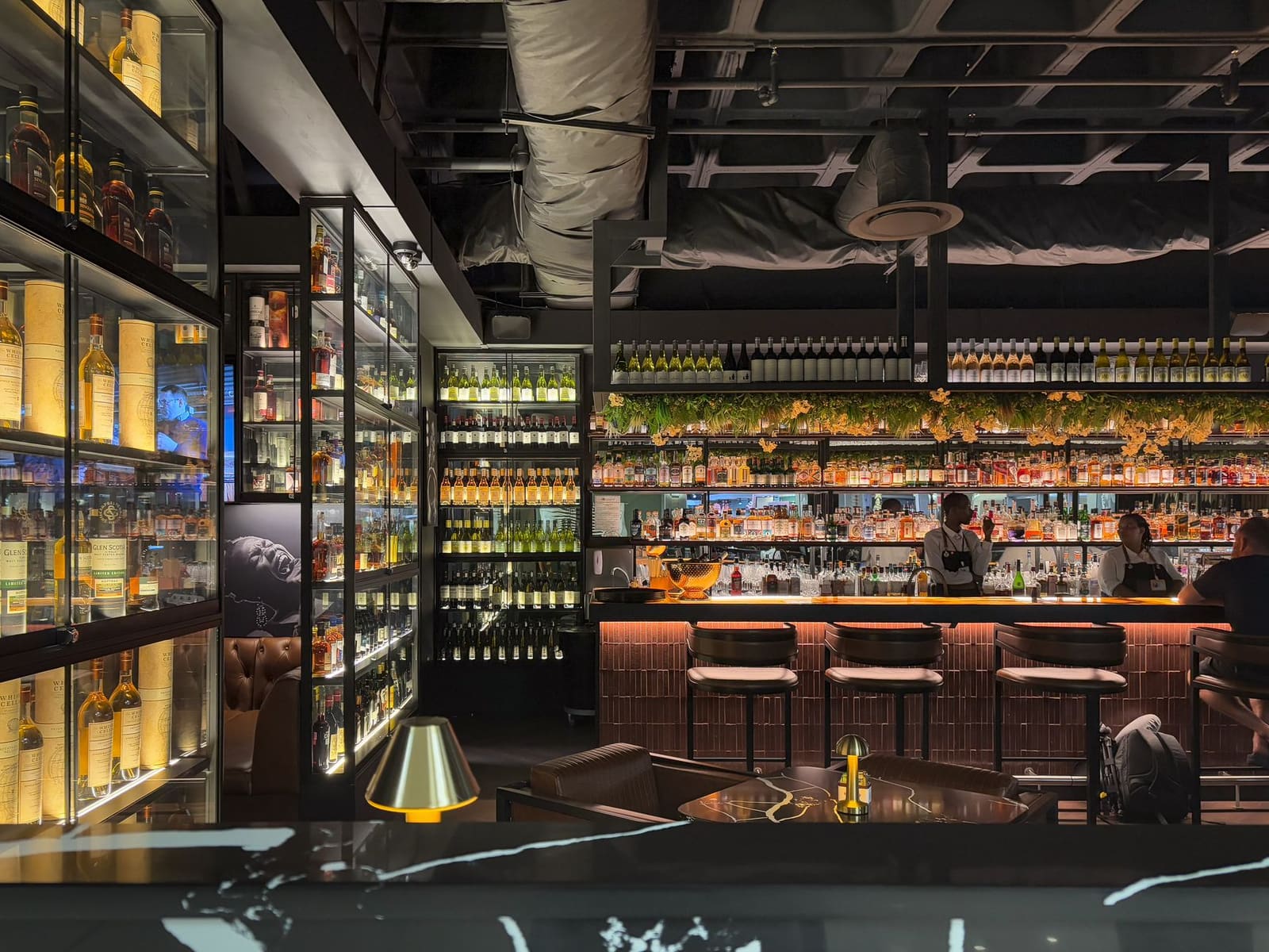 Sfeervol interieur van een internationale cocktailbar met bar en flessen op de achtergrond