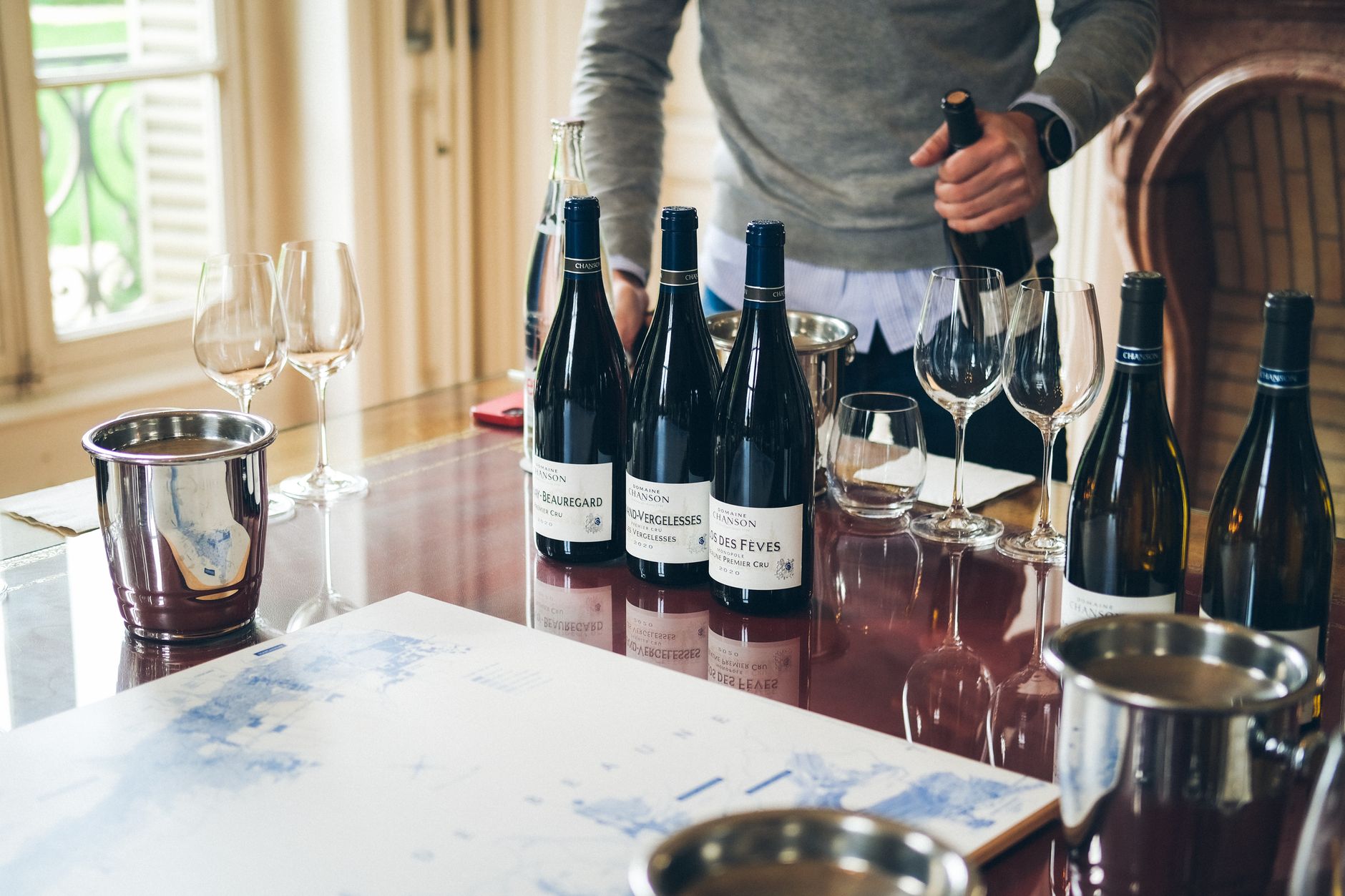 Sommelier schenkt een glas rode wijn in bij een gedekte tafel in een restaurant