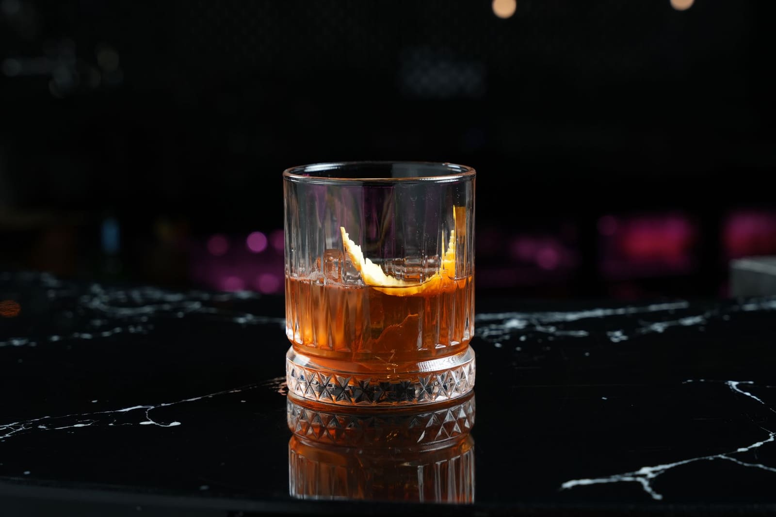 Old Fashioned cocktail met een groot rond ijsblok in een laag glas