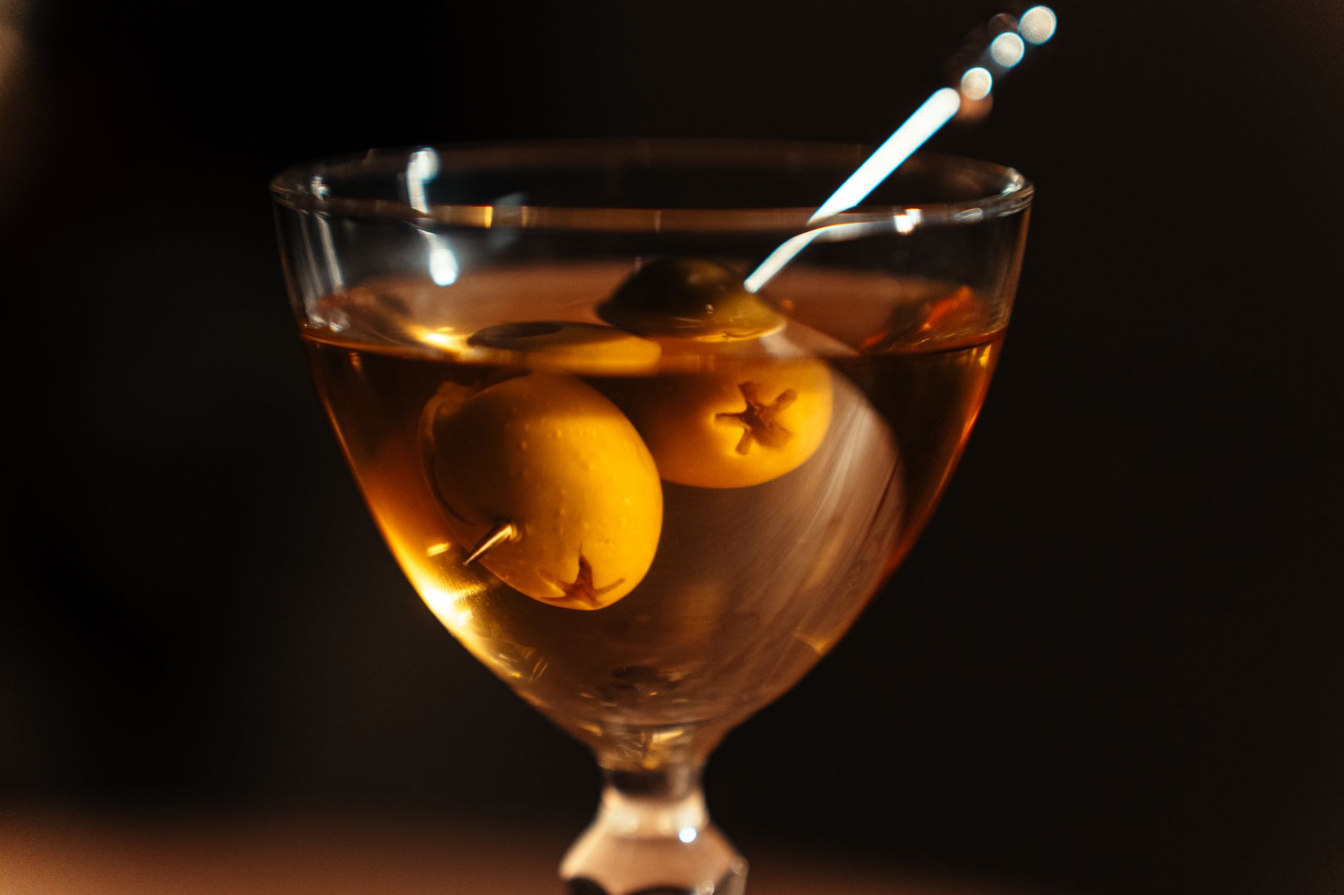 Bartender schenkt een sherrycocktail in een glas achter de bar