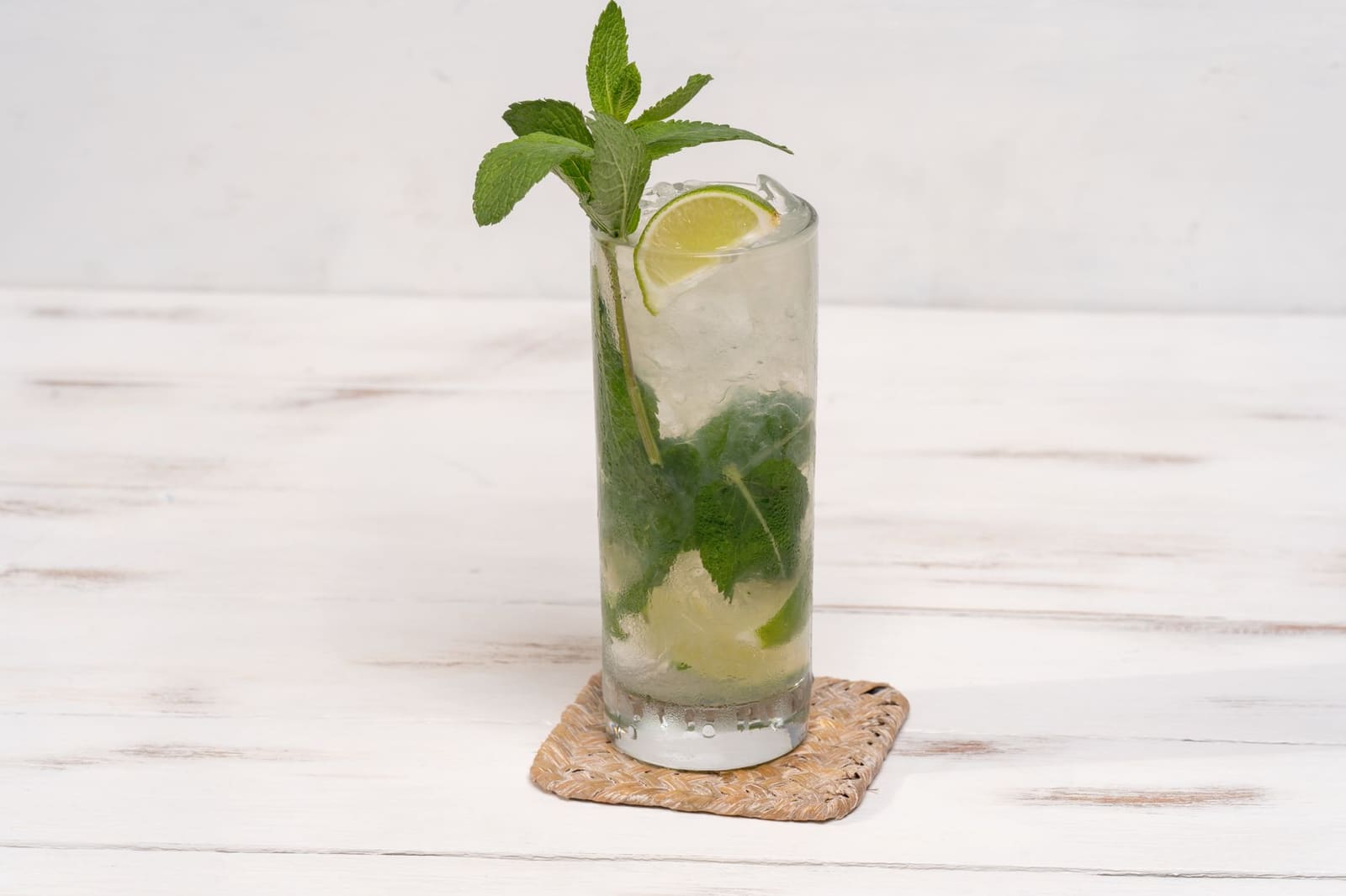 Een hoog glas vol ijs met bubbelende tonic, de klassieke opbouw van een longdrink.