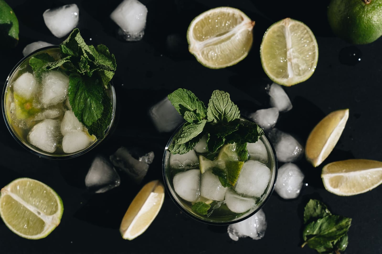 Verse limoen en munt op een donkere bar, de ingrediënten van een frisse mixdrank.