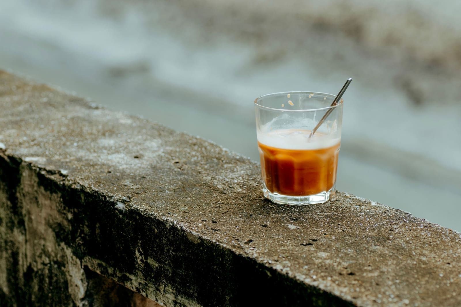 Barlepel met spiraal roert een helder drankje in een glas met ijsblokjes.