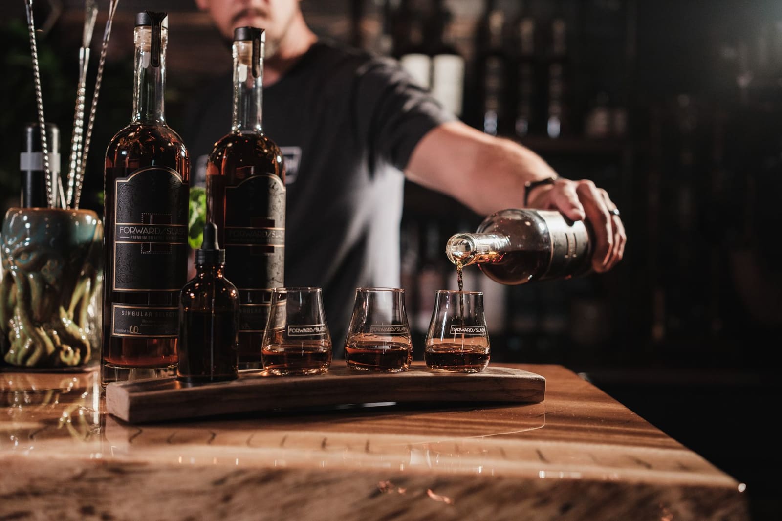 Bartender schenkt een sterkedrank zorgvuldig in een glas achter de bar