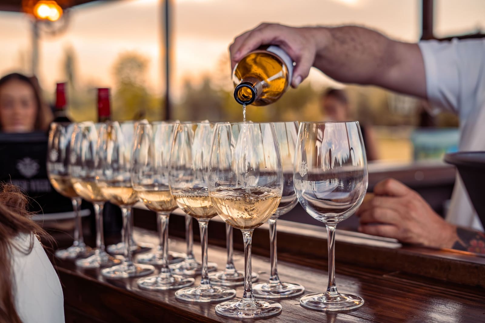 Wijn wordt ingeschonken in een glas aan een bar