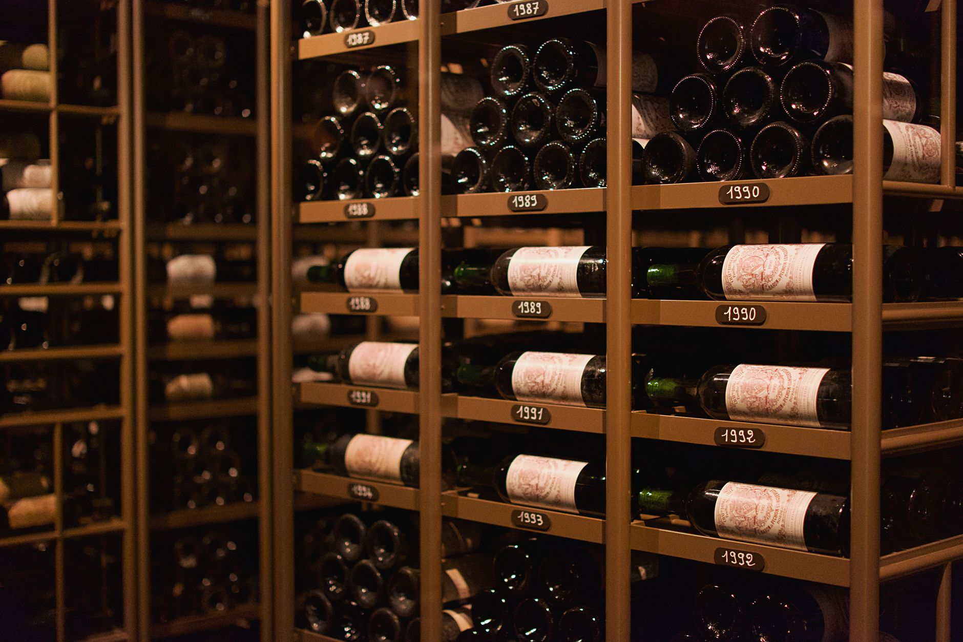 Rijen wijnflessen in een professionele wijnkelder waar fine wine wordt bewaard voor verzamelaars