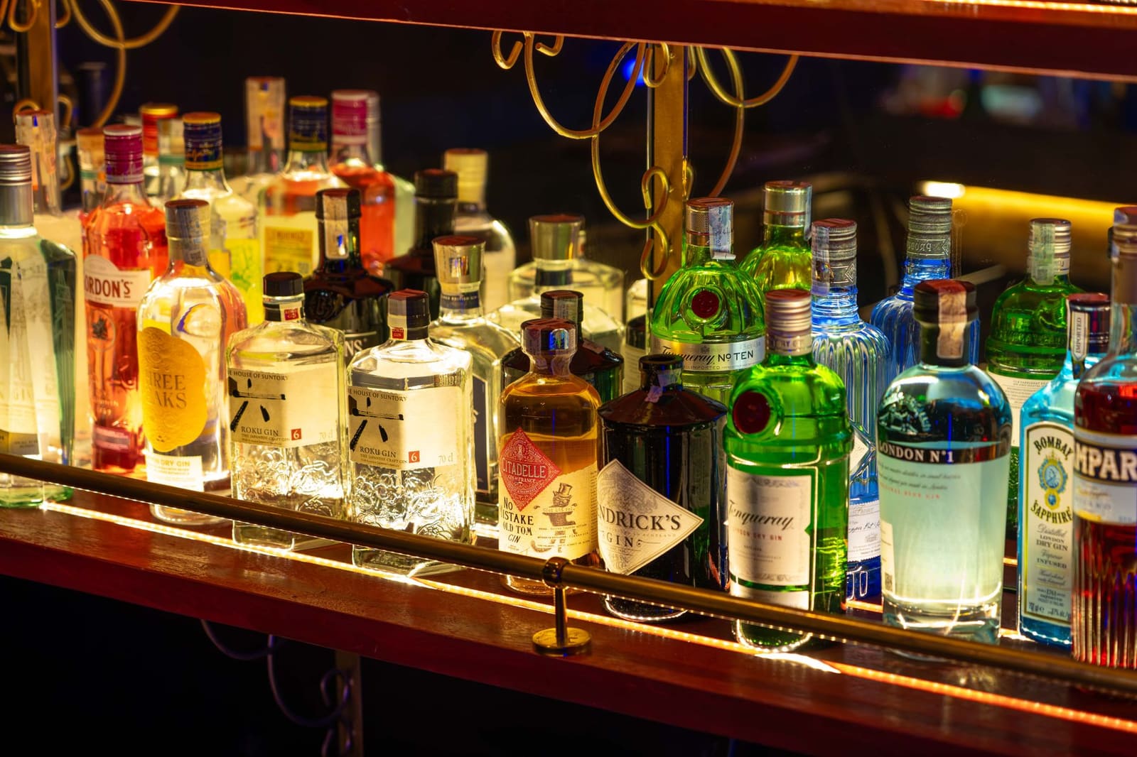 Flessen gin en likeur op een plank achter de bar voor cocktailbereiding