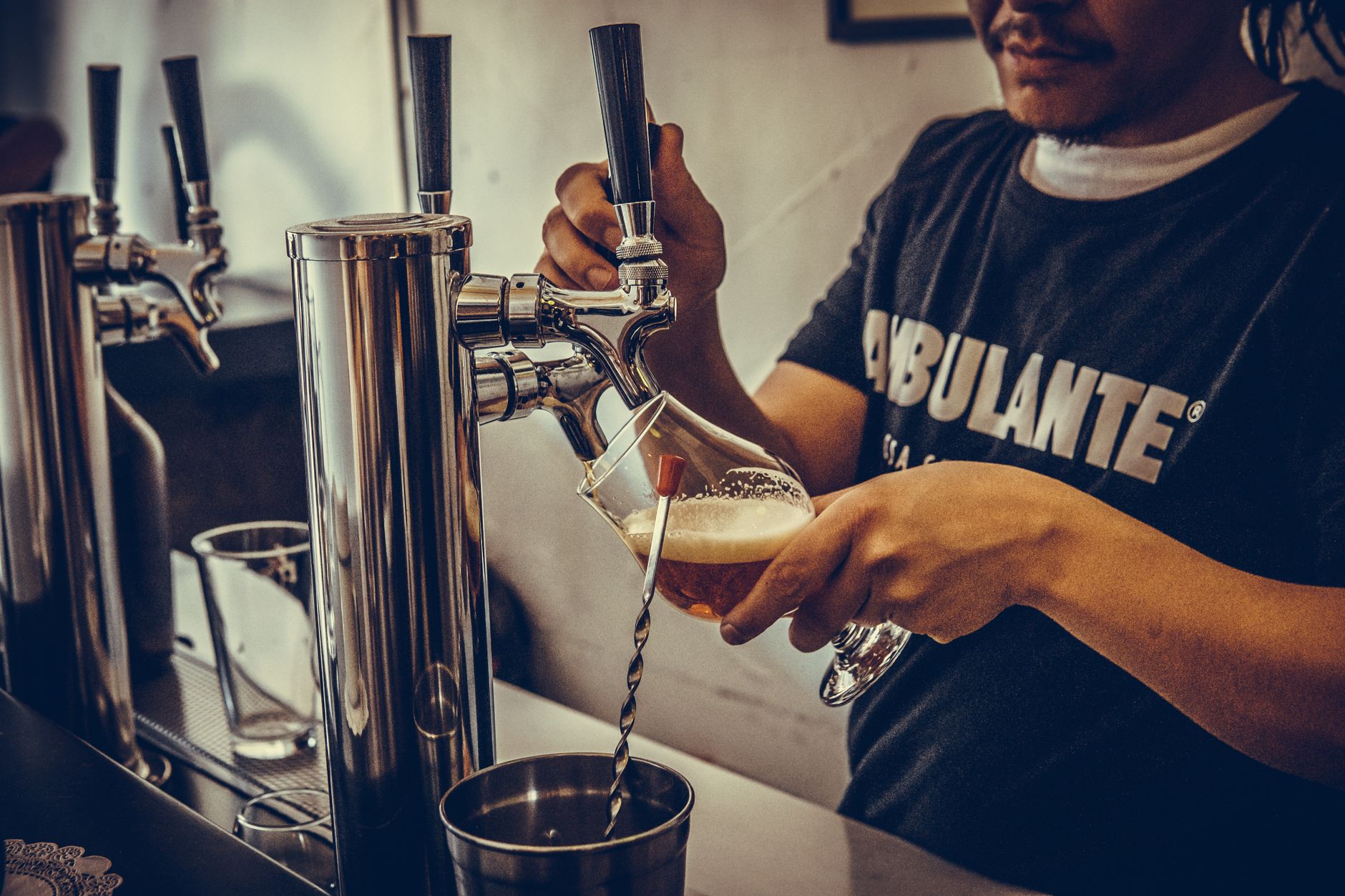 Getapt bier stroomt in een glas aan de tap tijdens een drukke voetbalavond in een café