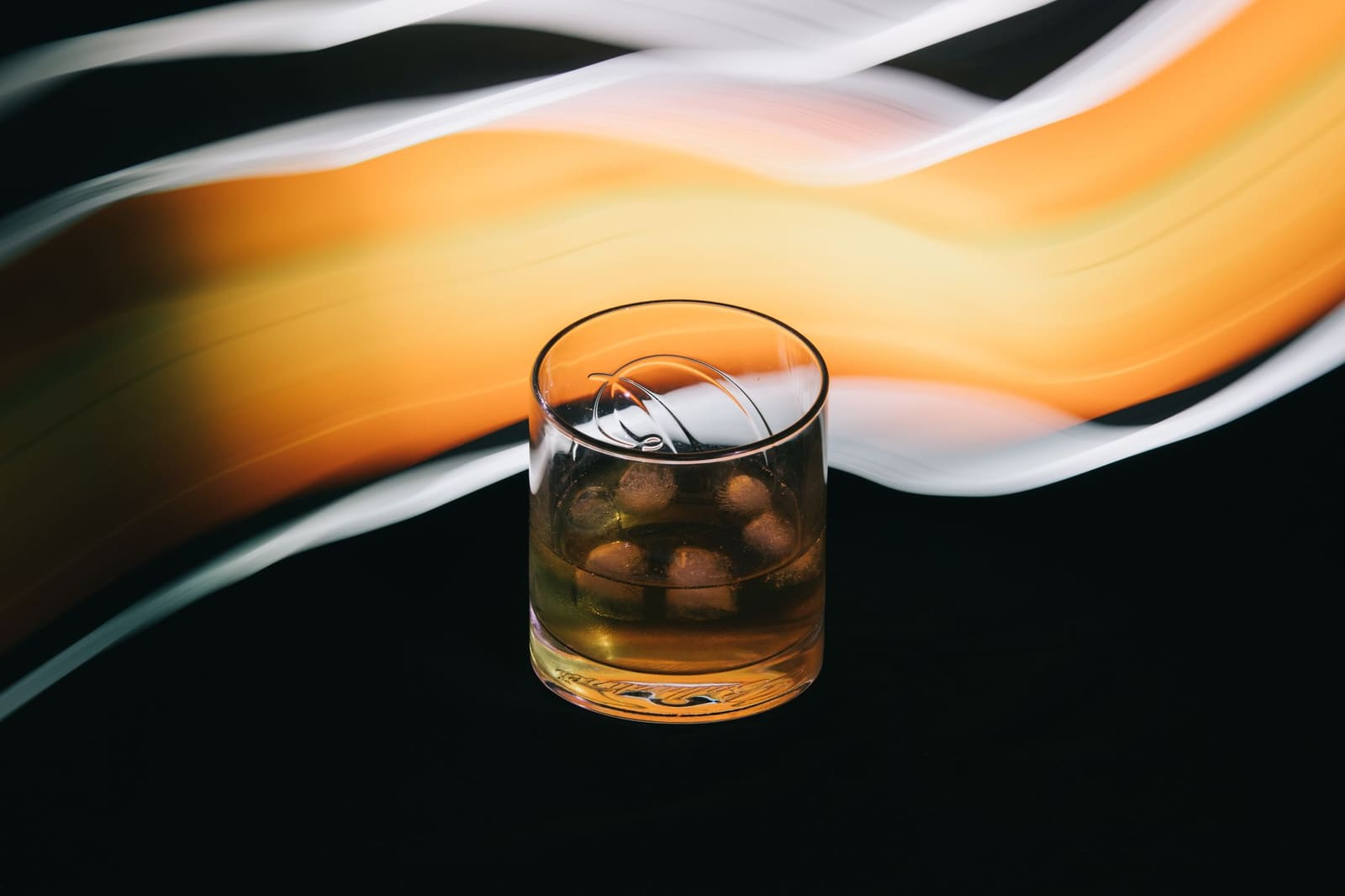 Een glas rogge-whiskey met een warme, amberkleurige glans op een donkere bar