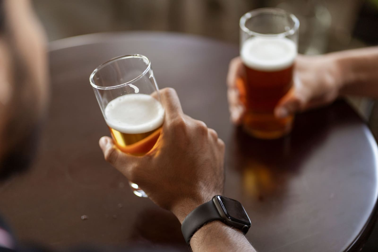 Glas ambachtelijk bier met schuimkraag en gouden kleur op een tafel