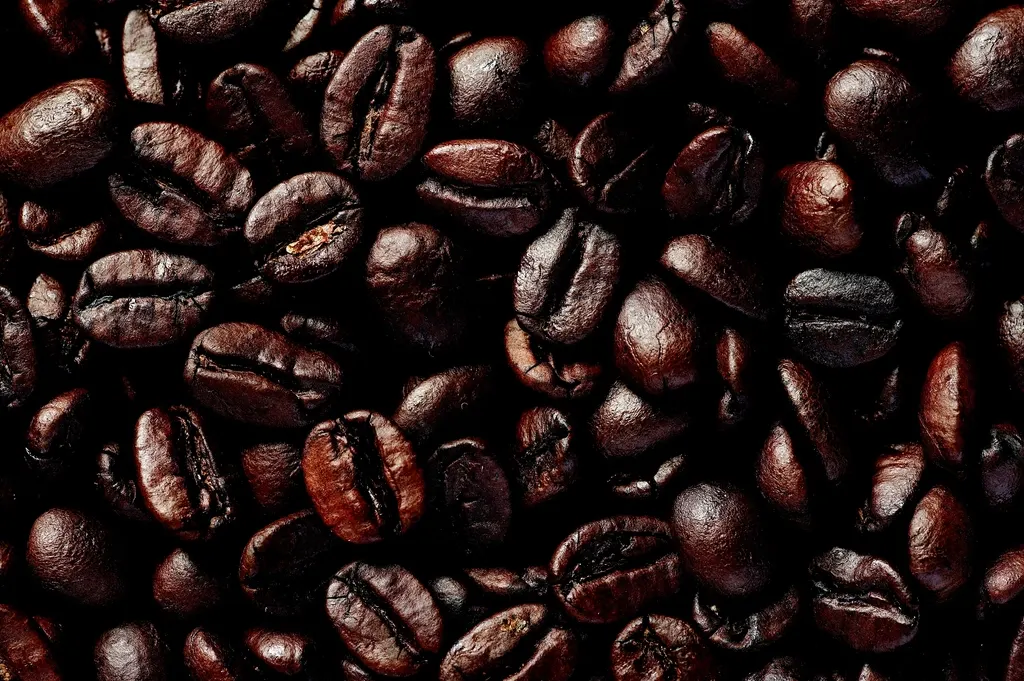 Close-up van verse koffiebonen uitgestrooid op een houten ondergrond